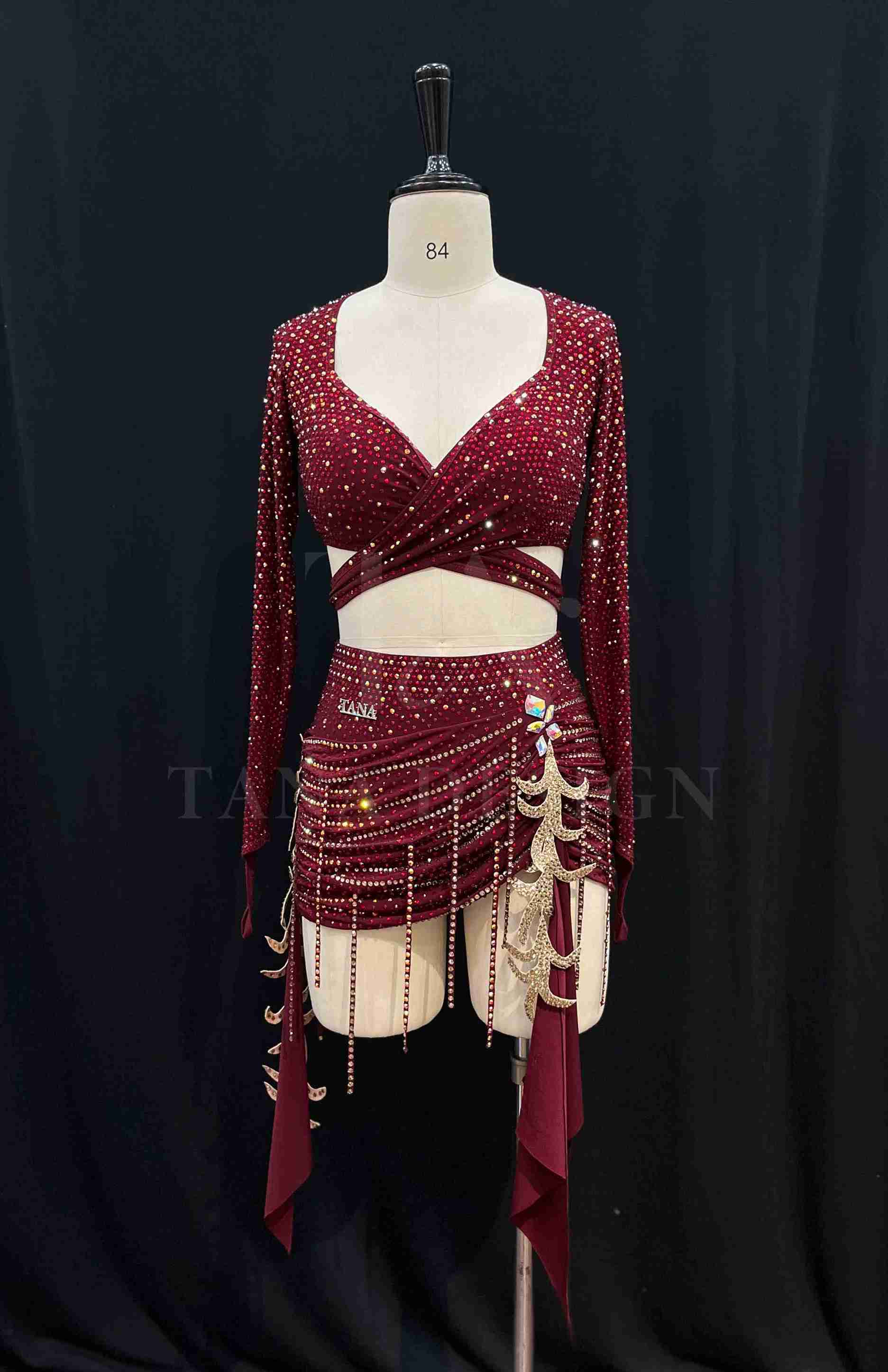 burgundy-two-piece-competition-dance-dress-tana-dancewear (3)_3_11zon Burgundy two-piece Latin dance costume with rhinestones, long sleeves, and fringe skirt details.
