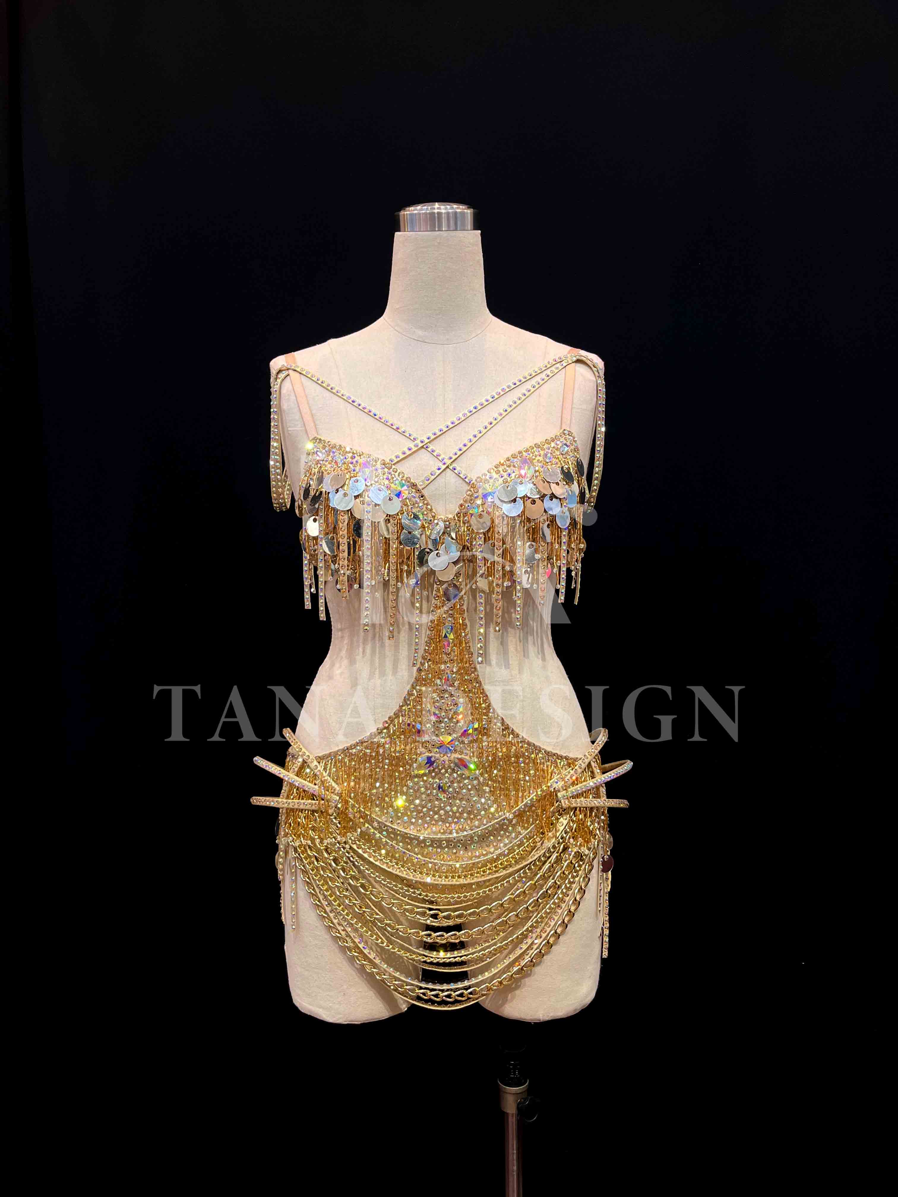 tana-women-competition-latin-dance-dress-gold-holographic (2) Gold holographic women competition Latin dance dress with open back, gold chains, and rhinestone fringe by Tana Dancewear.