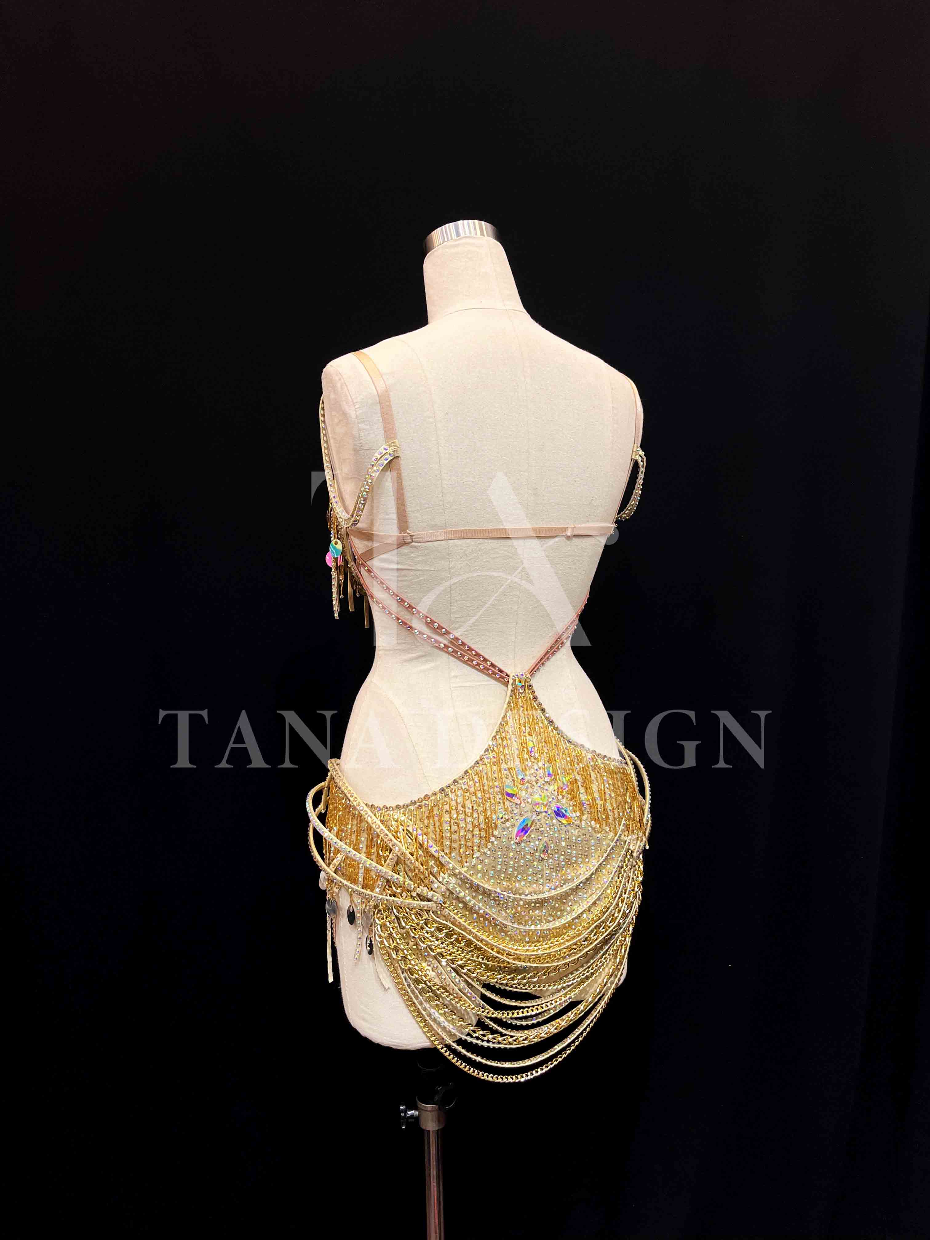 tana-women-competition-latin-dance-dress-gold-holographic (5) Gold holographic women competition Latin dance dress with open back, gold chains, and rhinestone fringe by Tana Dancewear.