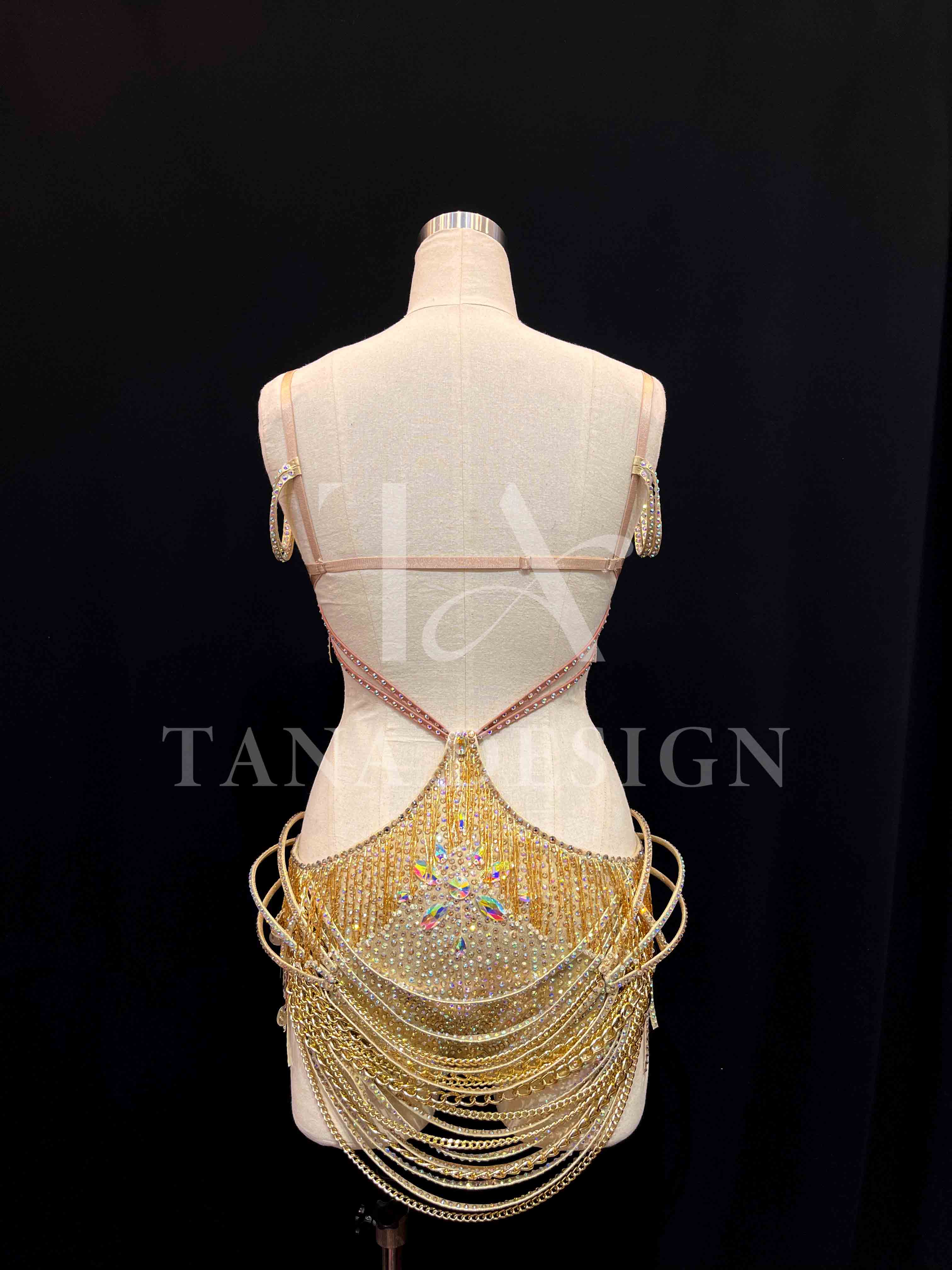 tana-women-competition-latin-dance-dress-gold-holographic (6) Gold holographic women competition Latin dance dress with open back, gold chains, and rhinestone fringe by Tana Dancewear.